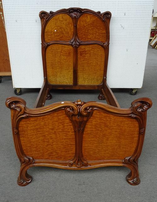 Eugene Gaillard (1862-1932); a figured ash and walnut bed frame, the headboard with a four panel back within an organically  carved frame, with matchi