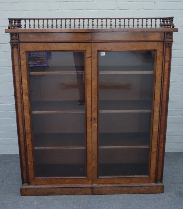 A Victorian figured walnut floor standing glazed two door bookcase on plinth base, 122cm wide x 146cm high x 39cm deep.