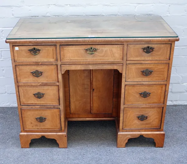 A late 19th century walnut kneehole writing desk with nine drawers about the knee cupboard, on bracket feet, 97cm wide x 76cm high x 46cm deep.