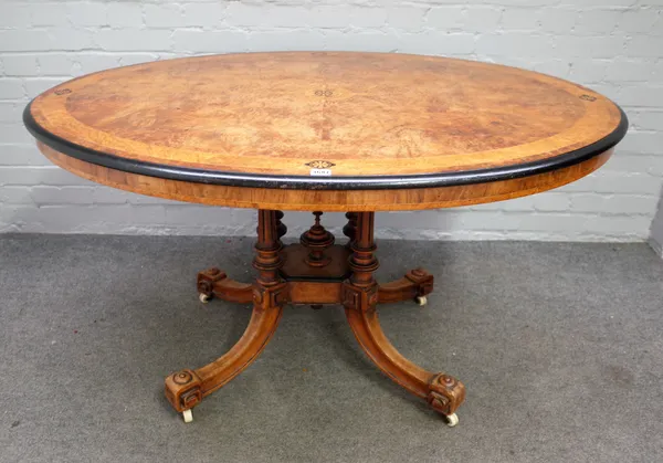 A Victorian marquetry inlaid figured walnut oval snap top loo table on four downswept supports, 99cm wide x 130cm long.