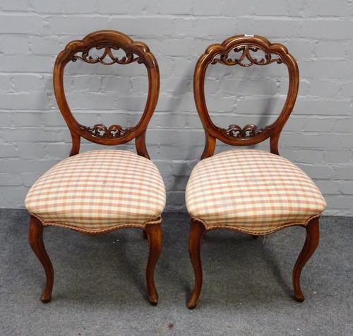 A set of four Victorian walnut balloon back dining chairs with serpentine seats, 45cm wide x 86cm high.