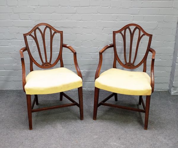 A pair of George III mahogany shield back carver chairs on tapering square supports, 59cm wide x 93cm high.