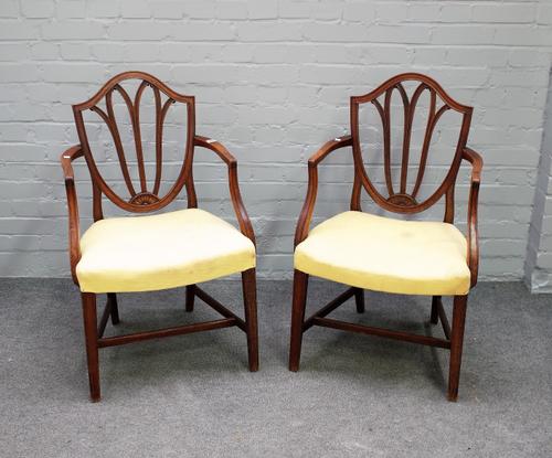 A pair of George III mahogany shield back carver chairs on tapering square supports, 59cm wide x 93cm high.