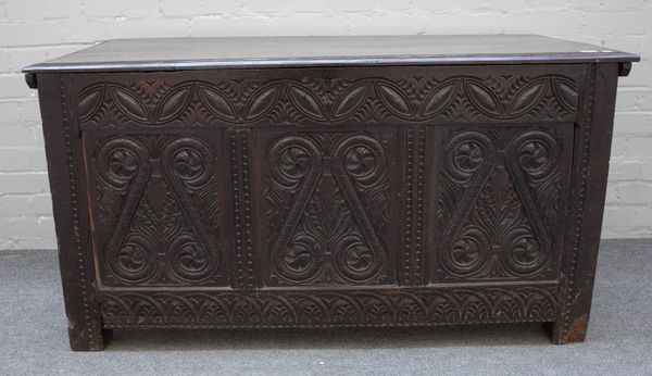 A 17th century oak coffer, the twin plank lid over triple panel front and double panelled sides, on stile feet, 129cm wide x 68cm high x 60cm deep.