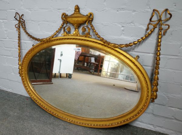 An Adams Revival gilt framed oval wall mirror with urn and swag decoration, 105cm wide x 70cm high.