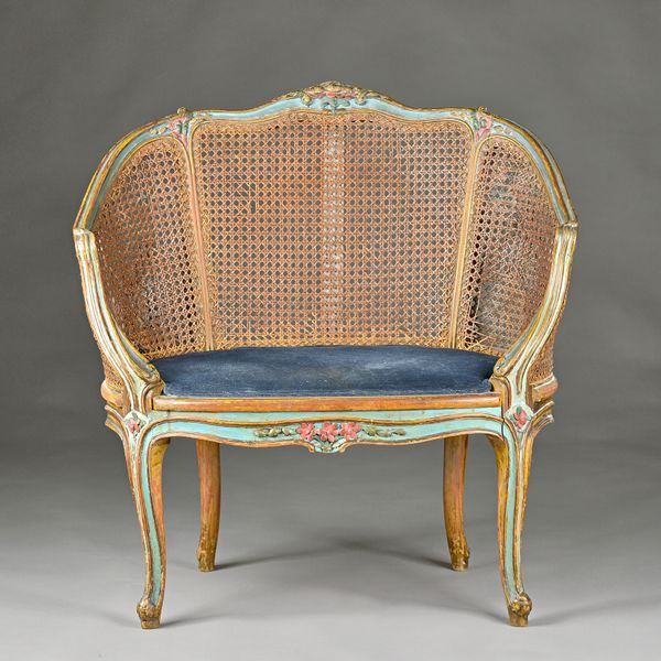 A 19th century French polychrome painted tub back armchair, on scroll supports, 85cm wide x 87cm high. Illustrated.