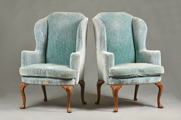 A pair of George II style wingback armchairs on shell capped walnut cabriole supports, 81cm wide x 120cm high. Illustrated.