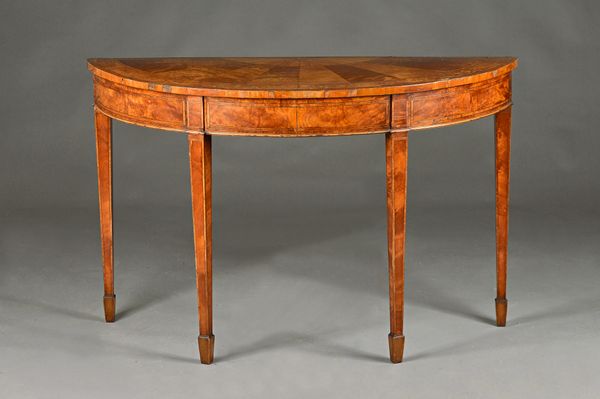 A George III satinwood and walnut marquetry inlaid demi-lune console table on tapering square supports, 131cm wide x 84cm high. Illustrated.