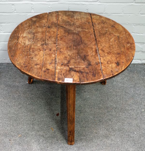 An 18th century oak cricket table on asymmetric stretcher base, 64cm diameter x 52cm high.