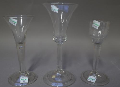 Three plain stemmed wine glasses, circa 1740, one with bell bowl, another with drawn trumpet bowl and teared stem, the third with moulded ogee bowl, e