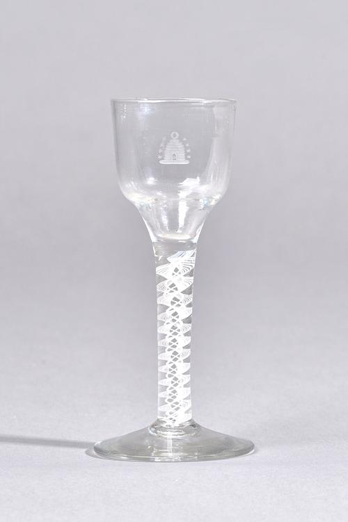 An engraved opaque twist stem wine glass, circa 1765, the ogee bowl engraved with a beehive, raised on a double series opaque twist stem and plain foo