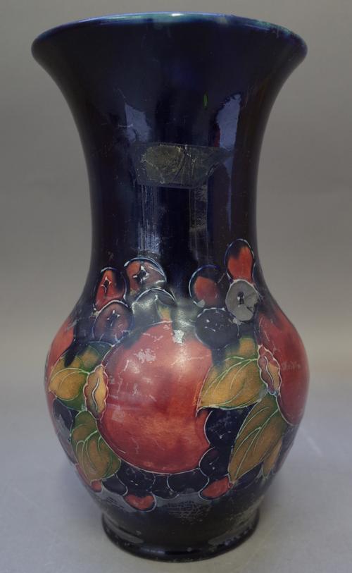 A Moorcroft pottery vase, 'Pommegranate' pattern, circa 1920, tube lined fruit against a cobalt blue ground, painted and printed marks, 25.5cm high, (
