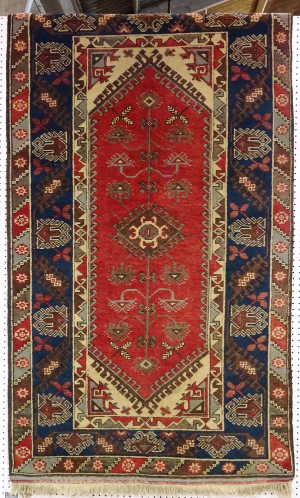 A Turkish rug, madder field, indigo border, 209cm x 118cm.  F4
