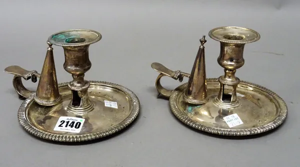 A pair of George IV silver chamber candlesticks, each of circular form with decorated rims, detachable sconces and with two snuffing cones, all pieces