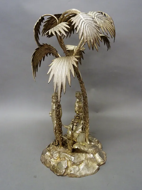 A Victorian silver table centrepiece, modelled as two palm trees raised on a rocky base, mounted with the standing figures of two gentlemen, one weari