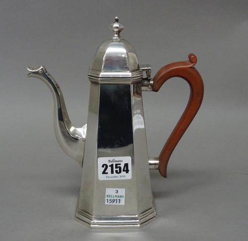 A silver coffee pot of tapering cut cornered square section form with a pale brown composition handle in the early 18th century taste, London 1932, gr
