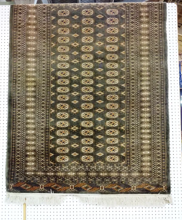 An Indian Bokhara rug, the dark sage field with three columns of eighteen guls, 176cm x 130cm and a silk Indian rug, vases of flowers, 126cm x 74cm, (