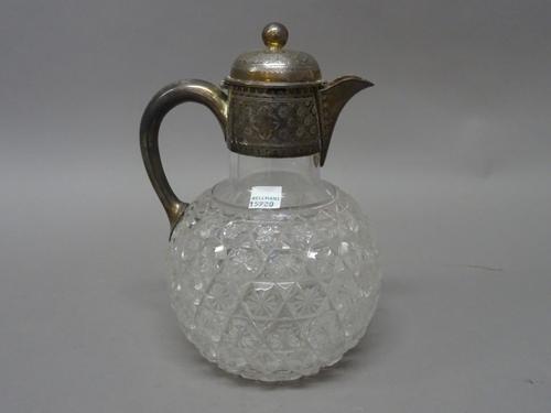 A late Victorian silver mounted faceted glass hinge lidded claret jug, with engraved decoration to the mount and with a spherical finial, Sheffield 18