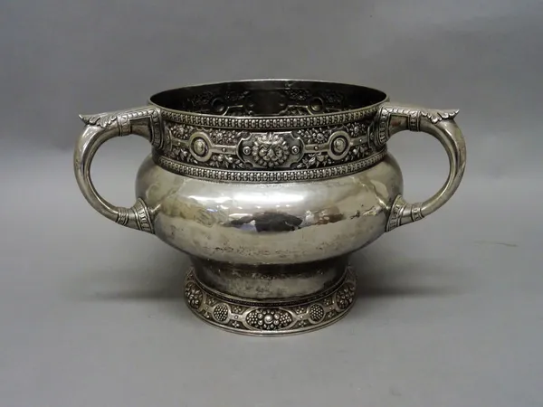 A large silver three handled centrepiece bowl, of curved baluster form, decorated with lion's masks, fruit and floral sprays within a beaded rim, the