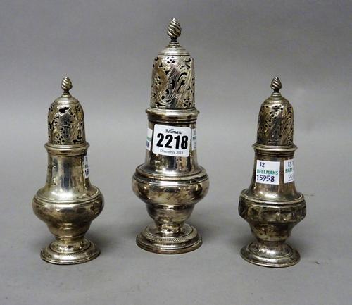 An early George III set of three silver sugar casters, each of inverted pear shaped form, with pierced and engraved decoration to the tops and with Wr