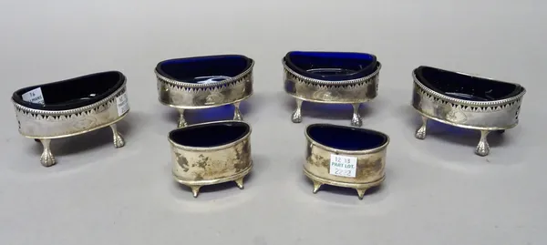 A George III set of four silver salts, each of oval form with pierced and engraved decoration, beneath a beaded rim and raised on four ball and claw f