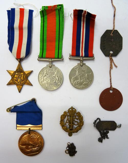Three Second World War medals comprising; The France & Germany Star, The Defence Medal and The War Medal, an A.T.S cap badge, two identity discs, a me
