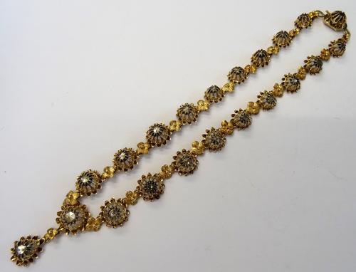 A gold and silver set rose diamond necklace, designed as a row of graduated flowerhead shaped links, mounted with rose diamonds to the centre of each