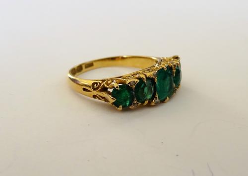 A late Victorian 18ct gold, emerald and green gem set five stone ring, with rose diamond points at intervals, (one rose diamond point lacking), the mo