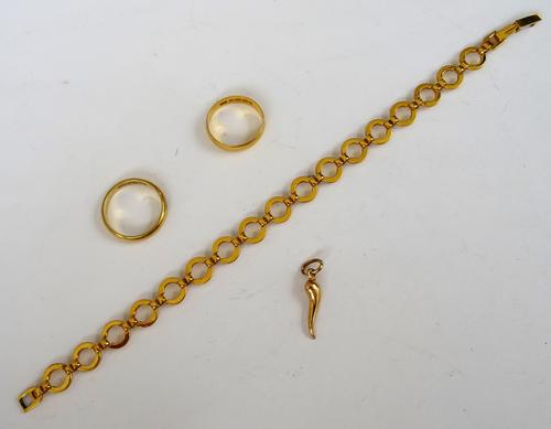A 22ct gold plain wedding ring, weight 2.8 gms, an 18ct gold plain wedding ring, weight 3.7 gms, a gold charm, detailed 750 and a gilt metal circular