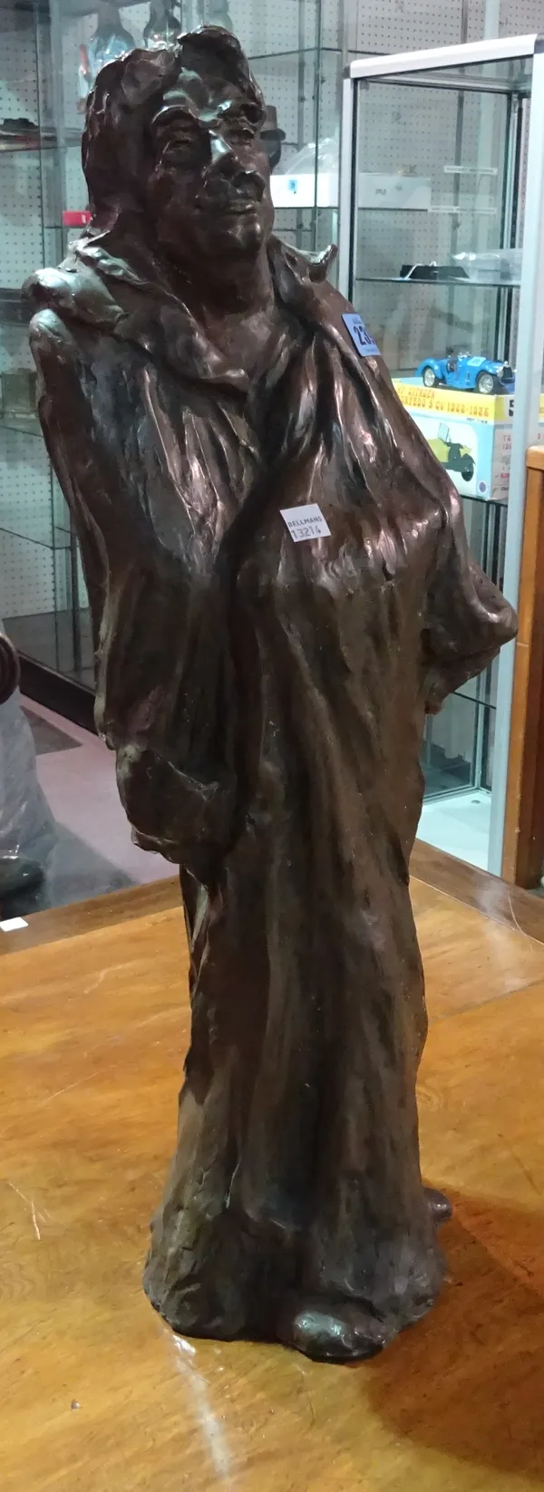 A large faux bronze resin figure of a man weaving a shawl.    BAY 1