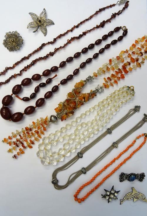 A single row necklace of coral beads, a two row necklace of graduated faceted rock crystal beads, an Asian four row necklace with niello decoration at