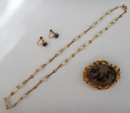A Victorian gold mounted oval moss agate brooch, the scroll pierced surround with engraved decoration, the back glazed with a woven hair locket compar