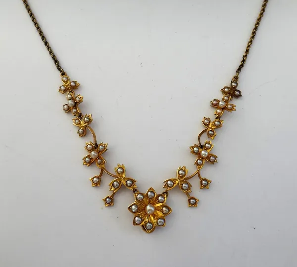 A gold and seed pearl set necklace, in a graduating floral and foliate openwork design, mounted with half pearls, on a ropetwist link neckchain, with