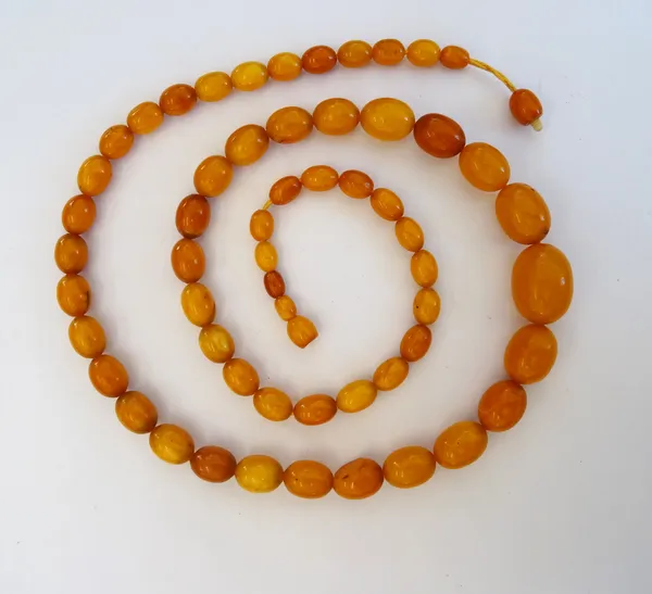 A single row necklace of graduated oval varicoloured butterscotch coloured amber beads, length of necklace 83.5 gms, gross weight 56 gms.
