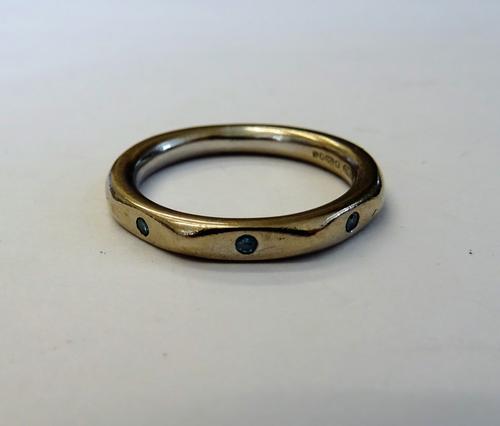 An 18ct  white gold and blue diamond set band ring, mounted with three circular cut blue diamonds, ring size I and a half, gross weight 4.2 gms, with