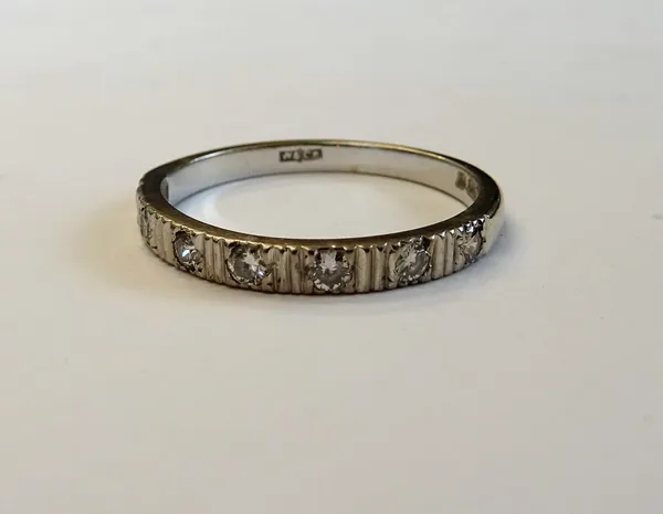 An 18ct white gold and diamond seven stone half eternity ring, mounted with a row of circular cut diamonds, between ridged divisions, ring size N and