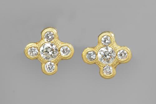 A pair of gold and diamond set five stone earstuds, each mounted with the principal circular cut diamond to the centre, in a surround of four smaller