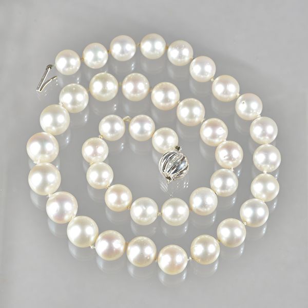 A single row necklace of South Sea cultured pearls, on an 18ct  white gold and diamond set spiral decorated spherical clasp, the thirty-nine cultured