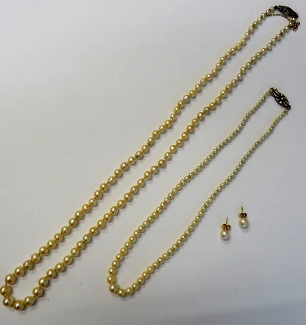A pair of gold mounted single cultured pearl earstuds, the backs with post and butterfly clip fittings, a single row necklace of graduated cultured pe