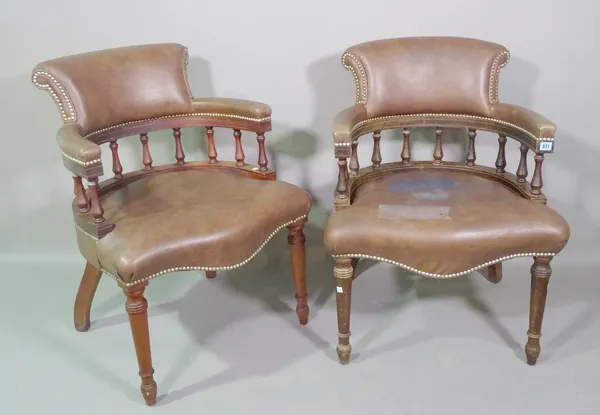 A pair of early 20th century mahogany framed captains armchairs with brown leather upholstery on tapering supports, (2).   C6