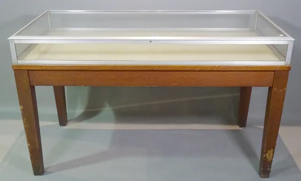 A Remington Rand library bureau, 20th century, the rectangular lift top glass display table on oak tapering supports, 152cm wide x 93cm high.   C6