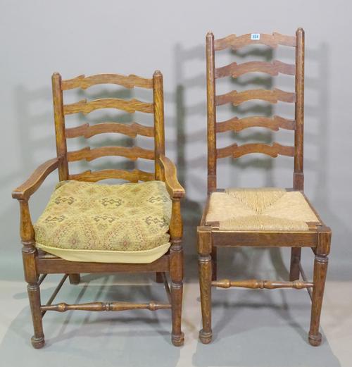 A set of six early 20th century oak ladder back dining chairs with rush seats, to include one carver, (6).   BAY 2