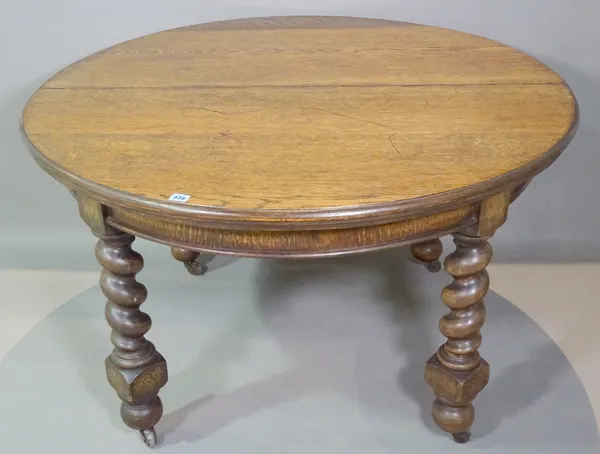 An early 20th century oak circular dining table on barley twist supports, to include two extra leaves, 120cm wide x 74cm high x 240cm fully extended.