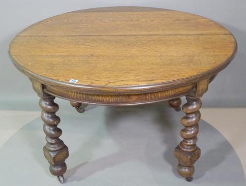 An early 20th century oak circular dining table on barley twist supports, to include two extra leaves, 120cm wide x 74cm high x 240cm fully extended.