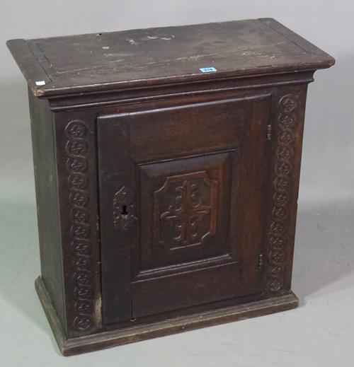 An 18th century and later oak hanging cupboard with panelled door, 68cm wide x 68cm high.   J6