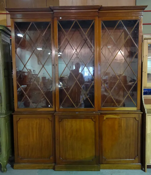 A George III style mahogany breakfront bookcase cabinet with three astragal glazed doors over three panel cupboards, 192cm wide x 241cm high x 40cm de