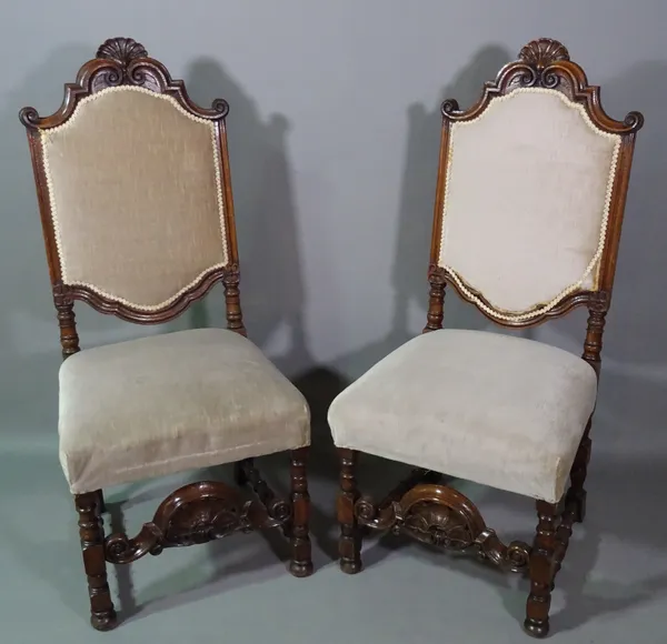 A pair of late 19th century carved oak side chairs of 17th century Flemish design, pierced stretcher on block and turned supports, 53cm wide x 125cm h