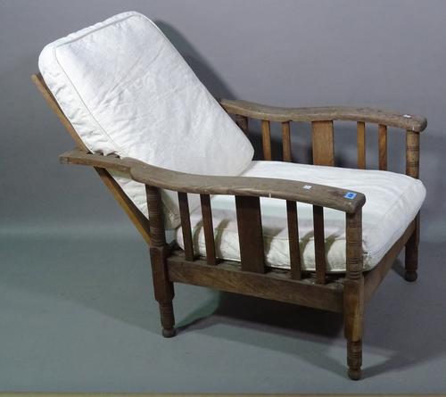 An early 20th century oak reclining open armchair on ring turned supports.   G8
