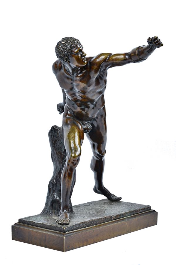 A patinated bronze figure of a Roman gladiator, late 19th century, modelled naked with his arm outstretched, on a naturalistic rectangular base, unsig