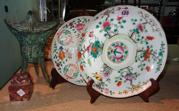 Two Chinese famille-rose plates, 20th century, painted with flowers and fruit, each approx. 22cm. diameter, wood stands; also a soapstone seal surmoun